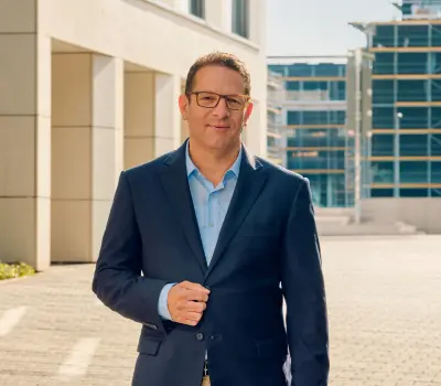 Mann im geschäftlichen Kontext, stehend vor einem Gebäude