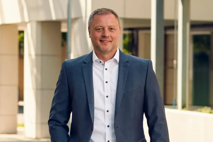 Mann im geschäftlichen Kontext, stehend vor einem Gebäude