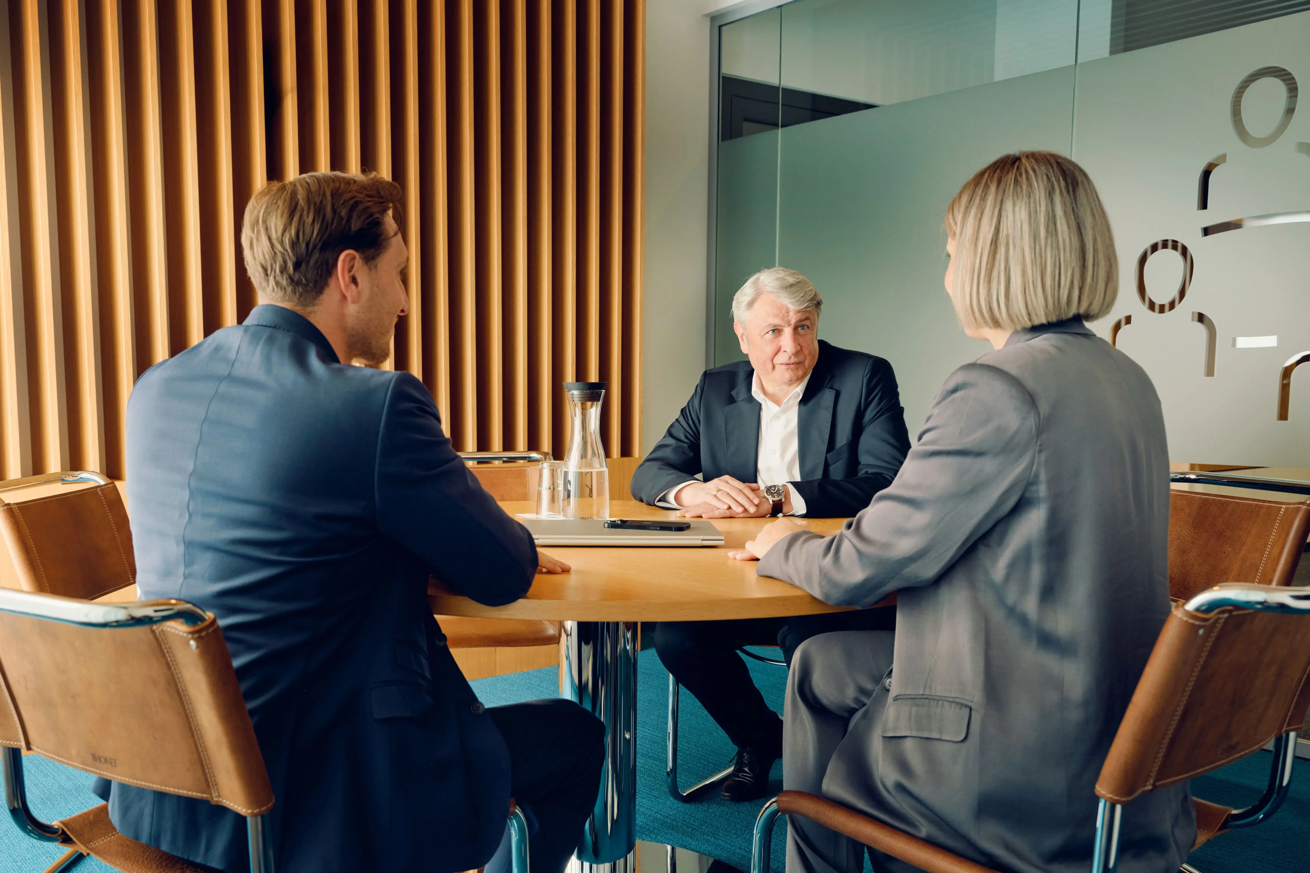 Zwei Männer und eine Frau in Besprechungssituation